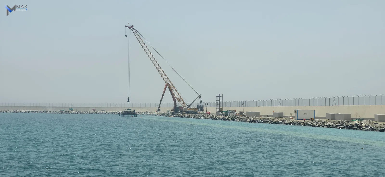 Al Rughaylat Port — crane operations beside the breakwater