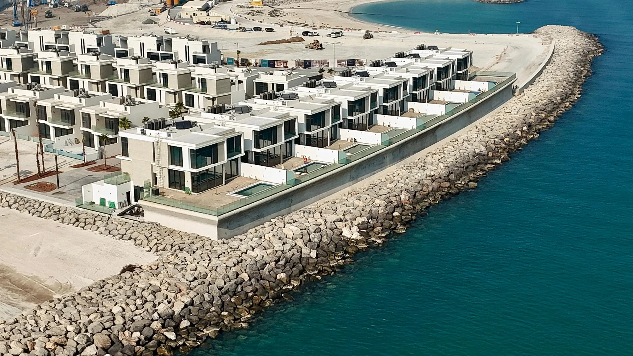 Al Marjan Island — close aerial view of the revetment and villa frontage